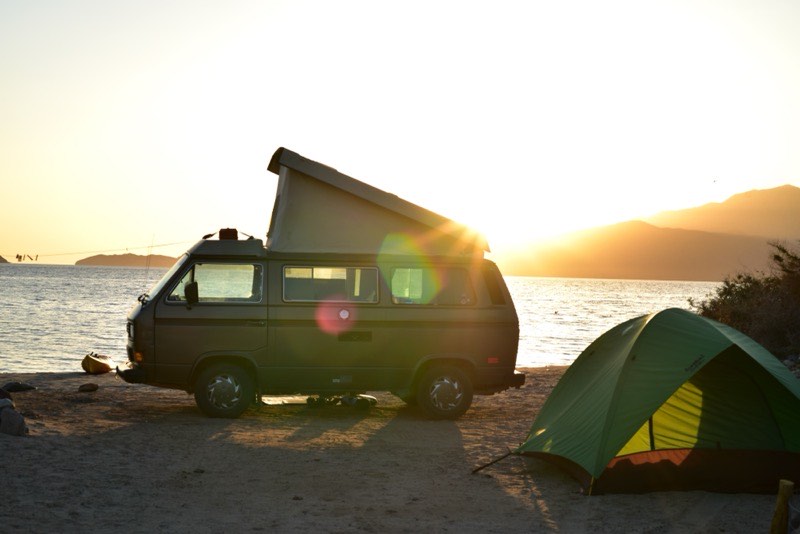 VW T3 Westfalia mit aufgestelltem Hubdach im Gegenlicht bei Sonnenaufgang